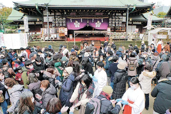 お守りが入った封筒を交換し合う参拝者ら