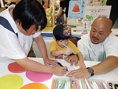 来年オープン予定の「鳥取県立美術館」ブースでは親子連れがうちわ作りを楽しんだ