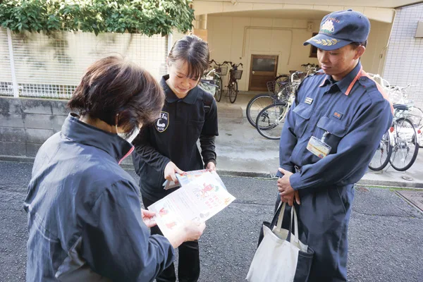 地域の住人に説明をする部長の大脇世里那さん（中央）と消防士の宮崎颯太さん（右）