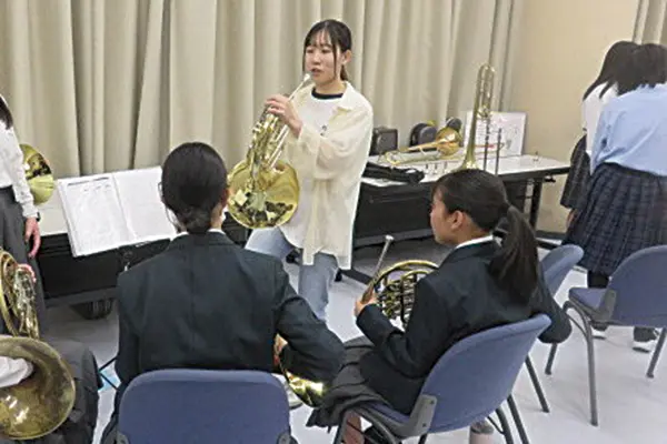 ルミエールホールで生徒に楽器指導する地元吹奏楽団のメンバー