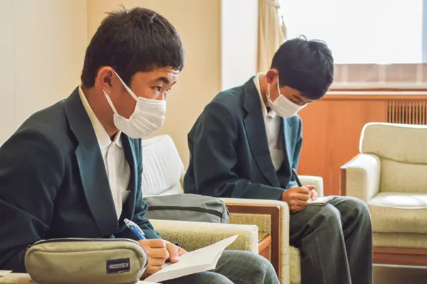 真剣なまなざしでメモを取る2人